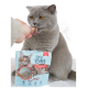 Eine graue Katze mit bernsteinfarbenen Augen leckt einen Leckerbissen aus der Hand einer Person, neben einem Beutel mit "Cat's Love Pure Bites" gefriergetrockenen Katzenleckerlis.