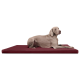 Ein grauer Weimaraner-Hund liegt auf einem burgunderfarbenen Haustierbett und schaut aufmerksam zur Seite.