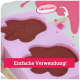Pinkfarbene Silikonform gefüllt mit braunen Haustierleckerlis, Text „Einfache Verwendung!“ und „Inkl. Eisstiel!“ mit einem Pfeil, der auf einen Holzstab zeigt.