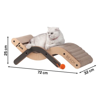 Eine weiße Katze entspannt sich auf einem Holz-Katzenbett mit strukturierter Oberfläche, das einen orangefarbenen Ball und die Gravur 'BEACH' an der Seite zeigt.