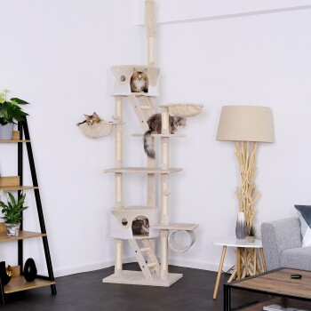 Ein hoher beiger Katzenbaum mit drei Katzen, die auf verschiedenen Ebenen entspannen, mit mehreren Plattformen, einem Tunnel und gemütlichen Körben.