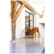 Zwei braune Hunde, die an einer erhöhten Futterstation in einem modernen Innenraum mit Holzbalken und einem großen Fenster im Hintergrund fressen.