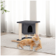 Eine verspielte orangefarbene getigerte Katze liegt auf einem strukturierten grauen Teppich neben einem schwarzen Katzenbaum mit einer höhlenartigen Öffnung und beigen Kratzpfosten.