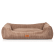 Ein plüschiges, beiges Haustierbett mit einem Cord-Textur und erhöhten Rändern, mit einem kleinen Lederetikett, auf dem "KNUFFELWUFF" steht.