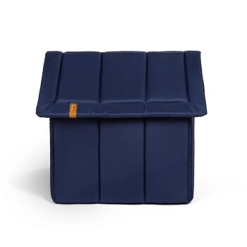 Navy-blaues, haushaltsförmiges Bett mit gepolstertem Dach und Seiten, mit einem kleinen braunen Etikett auf der Vorderseite.