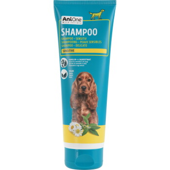 Tube de shampooing pour animaux AniOne Shampoo Sensitive avec photo de chien, illustrations de camomille et de sauge, étiquette 'Vegan' et logo de la marque.