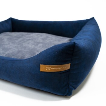 Navyblaues Haustierbett mit einem weichen grauen Innenraum und einem Lederschild, auf dem "RexProduct.com" steht.