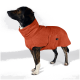 Ein Hund mit einem dunklen Fell steht vor einem schlichten Hintergrund und zeigt sein stilvolles und gemütliches Outfit mit einem orangefarbenen Fleece-Mantel.
