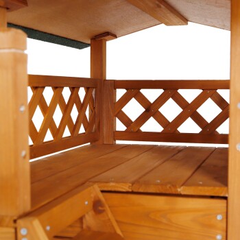 Innenansicht eines Holzhaustiers mit einer geräumigen Plattform, die mit Gitterwänden und einem schrägen Dach ausgestattet ist.