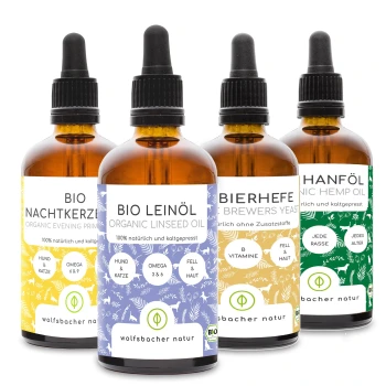 Vier Flaschen mit biologischen Haustierölen: Nachtkerzenöl, Leinsamenöl, Bierhefe und Hanföl, jede mit detaillierten Etiketten.