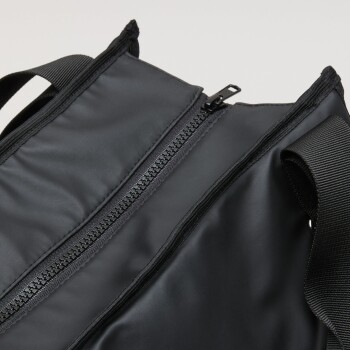 Nahaufnahme einer schwarzen Haustiertrage mit einem doppelten Reißverschluss und stabilen Riemen, entworfen für den Transport von Haustieren.