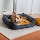 Ein gemütliches Hundebett mit einem dunkelgrauen Äußeren und einem goldgelben Kissen, in dem ein entspannter Hund liegt.