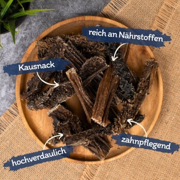 Kauende Haustiersnacks auf einem Holzbrett präsentiert, beschriftet mit den Texten: "Kausnack," "reich an Nährstoffen," "hochverdaulich," und "zahnpflegend."