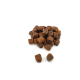 Een stapel kleine, donkerbruine huisdiertraktaties in de vorm van blokjes, verspreid op een witte achtergrond.