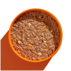 Eine Nahaufnahme einer Schüssel mit Haustierfutter, die eine glatte, fleischige Textur mit kleinen Gemüsestücken zeigt, vor einem orangefarbenen Hintergrund.