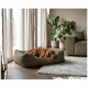 Roter Hund schläft in einem olivgrünen Cord-Hundebett mit Lederanhänger mit der Aufschrift KNUFFELWUFF in einem gemütlichen Wohnzimmer.