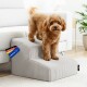 Brauner, lockiger Hund steht auf grauen, geriffelten Haustier-Treppen neben weißem Sofa; Etikett: 'DEUTSCHE MARK' und 'MADE IN EU'