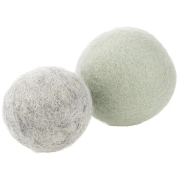 Zwei gefilzte Wolltrocknerbälle, einer grau mit schwarzen Flecken und einer hellgrün, eng beieinander positioniert.