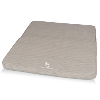 Ein plüschiges, beiges Haustierbett mit einer gesteppten Textur, das in einer Ecke das Logo "KNUFFELWUFF" in Weiß zeigt.