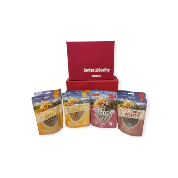 Eine rote Box mit der Aufschrift "Schweizer Qualität" enthält vier Pakete Haustierfutter: zwei "Soft Meaty" und zwei "Cat Sticks" mit Bildern von Katzen.