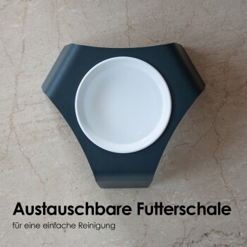 Eine elegante schwarze Futterschale für Haustiere mit einer abnehmbaren weißen Keramikschale, mit dem Text "Austauschbare Futterschale für eine einfache Reinigung."