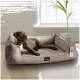 Ein brauner Hund, der auf einem plüschigen, grauen Hundebett in einem hellen Raum mit einer Pflanze und einem großen Fenster entspannt, mit einem Etikett, das "tierlando" liest.