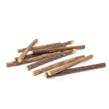 Ein Haufen natürlicher Kaustangen für Haustiere, unterschiedlich in Länge und Farbe, auf einem weißen Hintergrund.