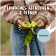 Person reißt eine perforierte grüne Hundekotbeutel mit sichtbarem Text „Einfaches Abtrennen & Öffnen“ und „Perforiert“.