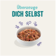 Schüssel mit Haustierfutter mit einer strukturierten Mischung, umgeben von verspielten Grafiken, und dem Text "Überzeuge DICH SELBST" darüber.