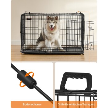 Ein flauschiger Hund sitzt in einer schwarzen Drahtkiste mit der Aufschrift "Fearndree" auf einem Holzboden, mit Nahaufnahmen eines Fußschutzes und eines Transportgriffs.