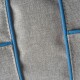 Nahaufnahme eines strukturierten grauen Stoffes mit blauer Naht, möglicherweise von einem Haustierzubehör oder einer Tasche.