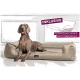 Ein brauner Hund sitzt auf einem beigen Hundebett, mit einem Textüberlagerung, die besagt: "INKLUSIVE MATRAZENSCHONER GIBT'S OBENDRAUF."