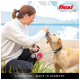 Une femme en pull blanc interagit avec un labrador retriever jaune sur une plage, tenant une laisse rétractable rouge.