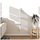 Ein moderner wandmontierter Katzenbaum mit drei grauen Plattformen auf einem weißen Pfosten, vor einer hellen Wand, neben einem gemütlichen Sofa und einer Topfpflanze.