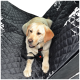 Ein gelber Labrador Retriever sitzt auf einem schwarzen, gesteppten Autositzbezug für Haustiere, der mit einem Geschirr gesichert ist.