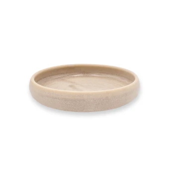 Ein beiges Haustierfutter- oder Wassernapf mit einem glatten, runden Design, mit einem leicht erhöhten Rand und einer strukturierten Oberfläche.