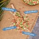 Bunte Haustierfutterpellets, die um eine Holzschaufel verstreut sind, beschriftet mit "mehrfarbig", "nährstoffreich", "schwimmt" und "mit Spirulina."