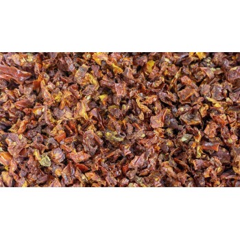 Getrocknete, zerstoßene rote Chilischoten, die auf einer Oberfläche verstreut sind und ihre reiche, rötlich-braune Farbe und strukturierten Flocken zeigen.