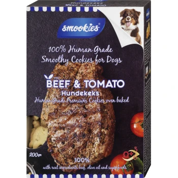 Boîte de Smookies 100 % Human Grade Smoothy Cookies pour chiens, avec une saveur de bœuf et de tomate, avec un steak de bœuf et des tomates visibles.