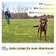 Eine Person auf einer grasbewachsenen Fläche hält eine gelbe Hundeleine mit einem braunen Hund neben sich. Der Text lautet: "Jede Länge für euer Abenteuer."