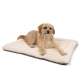 Ein flauschiger Hund ruht auf einem weichen, cremefarbenen Haustierbett mit grauem Unterboden und zeigt Komfort und Entspannung.