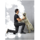 Eine Person in einem schwarzen Hemd und dunklen Hosen kniet und interagiert freudig mit einem großen, flauschigen Golden Retriever vor einem grauen Hintergrund.