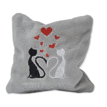 Graues Kissen mit gestickten schwarz-weißen Katzen in Herzform, roten Herzen und dem Text "TRUE LOVE" darunter.