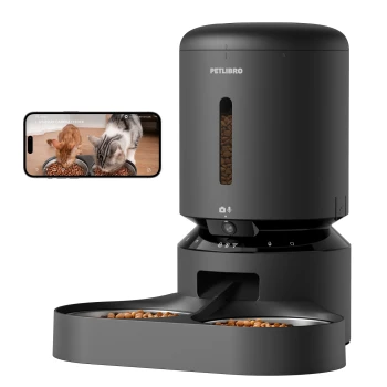 Intelligenter Futterspender für Haustiere mit Kamera, der zwei Katzen zeigt, die aus Schalen fressen, neben einem Smartphone, das den Live-Feed anzeigt.