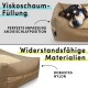 Ein Hund ruht auf einem bequemen Bett mit 'Viskoschaum-Füllung' für Schlafanpassung und 'Widerstandsfähige Materialien' für Langlebigkeit.