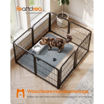 Getigerte Katze frisst in einem schwarzen Laufstall auf einer grauen Pfotenmatte; sichtbarer Text: 'feandrea' und 'Waschbare Hundeunterlage'.