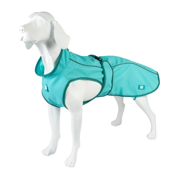 Weiße Hundefigur trägt türkisfarbenen wasserdichten Hundemantel mit dunklem Besatz, verstellbarem Bauchriemen und kleinem Logo-Etikett