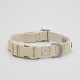 Beige Hundehalsband mit einem Kunststoffverschluss und einem Metall-D-Ring, auf einem hellgrauen Hintergrund präsentiert.