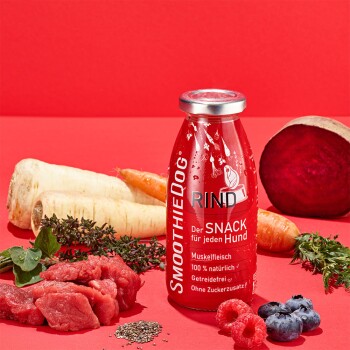 Eine SmoothieDog Rind-Hundesnackflasche auf rotem Hintergrund, umgeben von frischem Gemüse und Beeren, mit "bestes Fleisch" und "100% natürlich."