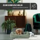 Ein kleiner Hund ruht sich in einem gemütlichen Bett aus, umgeben von stilvollem Dekor mit dem Text "ZUM EINKUSCHELN" und "schafft ein gemütliches Ambiente."